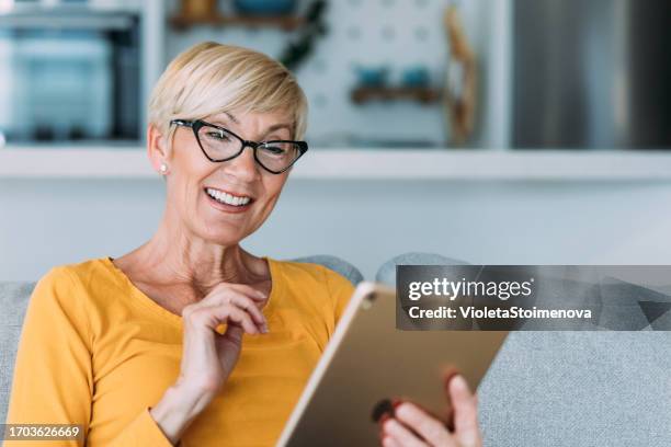 frau mit digitalen tablet zu hause. - autonomo smartphone tablet stock-fotos und bilder