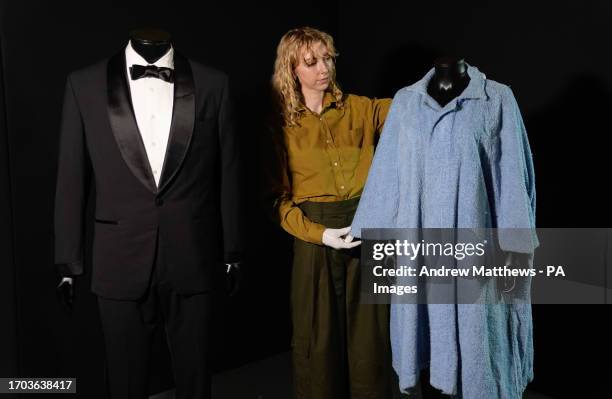 Propstore employee adjusts Honey Ryder's bathrobe from the 1962 James Bond film 'Dr No' which is alongside Daniel Craig's tuxedo from the 2021 James...