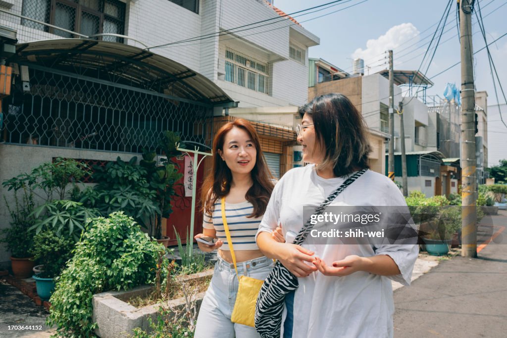 Two Asian women go shopping together and return home, chatting happily along the way, sharing the joys of their daily lives.