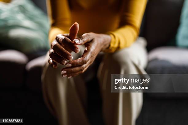 woman anxiously fidgeting her hands while struggling with negative emotions - knuckles stock pictures, royalty-free photos & images