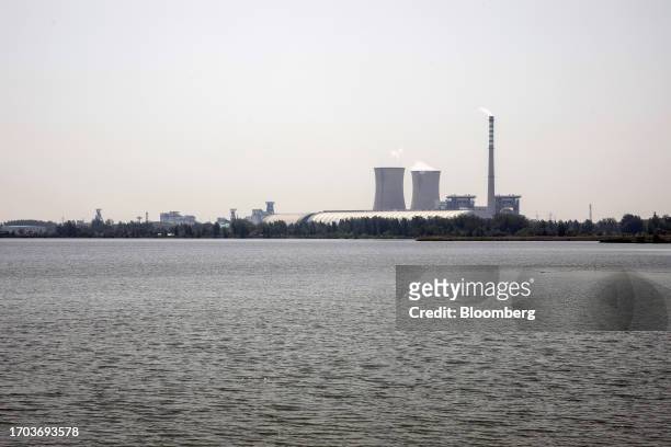 Thermal power plant near a floating solar farm of Sungrow Power Supply Co., not pictured, China, on Monday, May 15, 2023. The installation covers the...