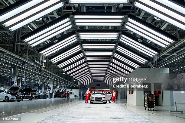 An employee cleans the windscreen of an Audi A3 automobile after completion at the new Audi AG production plant in Gyor, Hungary, on Wednesday, June...