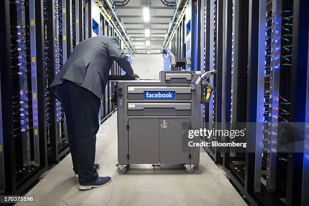 An employee inspects a tool and maintenance box, also known as a "crash cart" in the server hall at Facebook Inc.'s new data storage center near the...