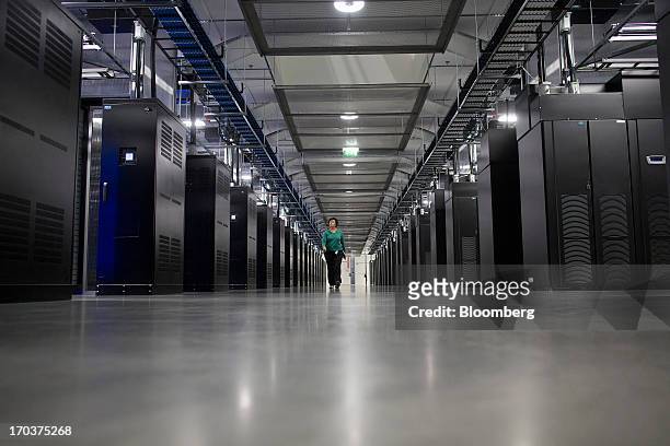 An employee walks past banks of data storage equipment in the server hall at Facebook Inc.'s new storage center near the Arctic Circle in Lulea,...