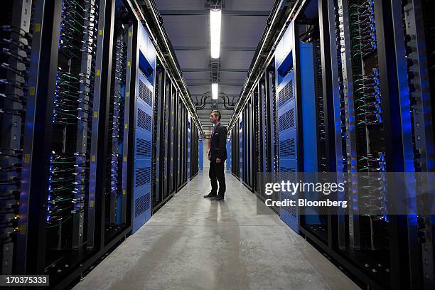 An employee stands between rows of data storage equipment in the server hall at Facebook Inc.'s new storage center near the Arctic Circle in Lulea,...