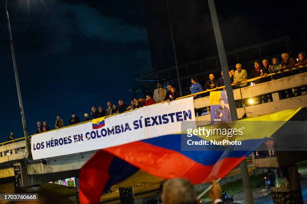Sign in support of Colombia's military and police forces is placed in an overpass as government oposers take part in a demonstration against the...