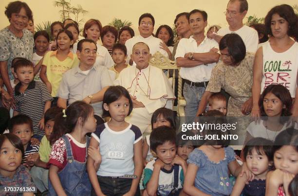 Influential Philippine church leader Cardinal Jaime Sin and street children from Manila have their photograph taken after hosting a lunch for poor...