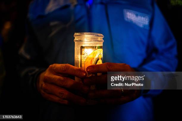 Demonstrator holds a christianity candle as government oposers take part in a demonstration against the government of Gustavo Petro in Bogota,...