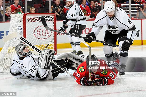 Jonathan Toews of the Chicago Blackhawks and goalie Jonathan Quick of the Los Angeles Kings lay on the ice as Drew Doughty of the Kings skates up...