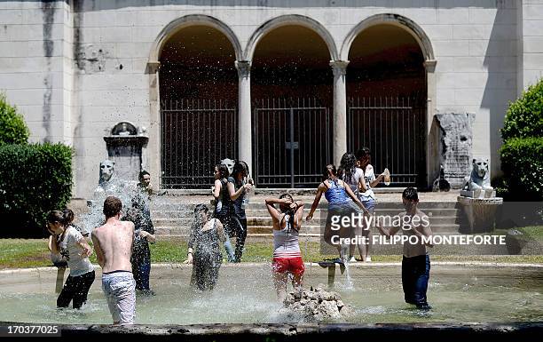 Youngsters play in fountains to celebrate the last day of school in downtown Rome on June 12, 2013. AFP PHOTO / Filippo MONTEFORTE