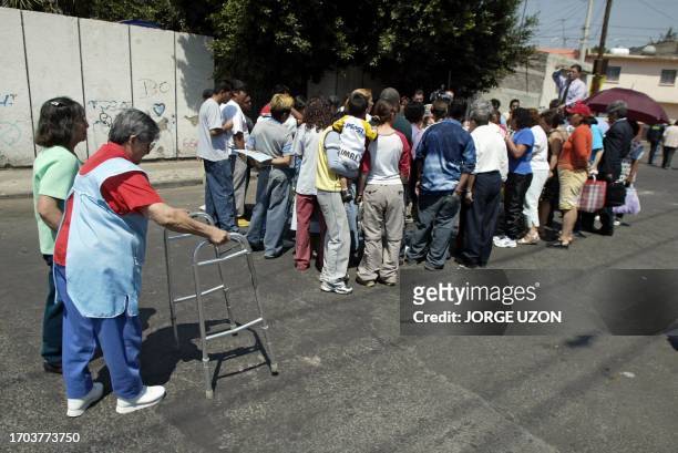 Faithful Catholics surround a street where an image of the Virgen de Guadalupe took form on the road in Mexico City 04 March 2003. Una anciana se...