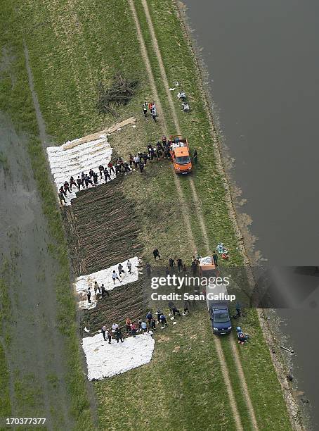 In this aerial view volunteers and firemen stack sandbags to strengthen a dyke at the flooding Elbe river on June 12, 2013 near Wittenberge, Germany....