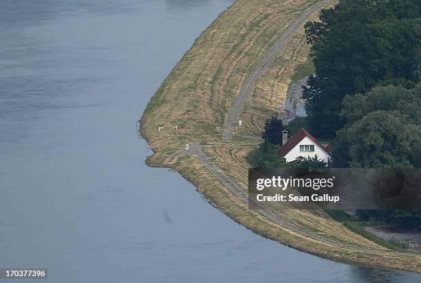 House stands next to a dyke protecting it from the flooding Elbe river on June 12, 2013 near Wittenberge, Germany. The swollen Elbe is continuing to...