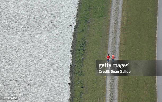 In this aerial view volunteers patrol a dyke to check for leaks along the bank of the Elbe river on June 12, 2013 near Wittenberge, Germany. The...