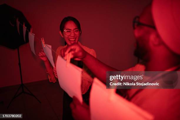 friends in a darkroom - donkere kamer stockfoto's en -beelden