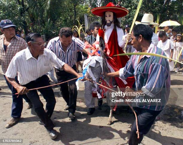 Parishioners pull a small donkey which carries a figure of Jesus, during the Donkey Procession on Palm Sunday 08 April 2001 in Nindiri, Masaya,...