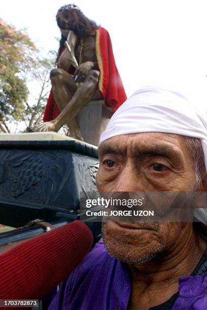 Catholic faithful participates in a religious procession 21 April 2000 in Old Guatemala for Holy Week. Un fiel catolico vestido con un traje tipico...