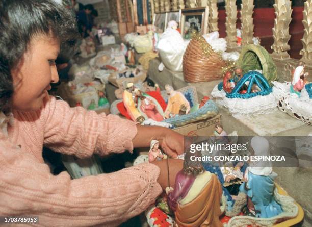 Bolivian Matilde Paez arranges her figurines of the birth of Jesus during the celebration of the Magi 06 January 2000 in La Paz. La joven boliviana...