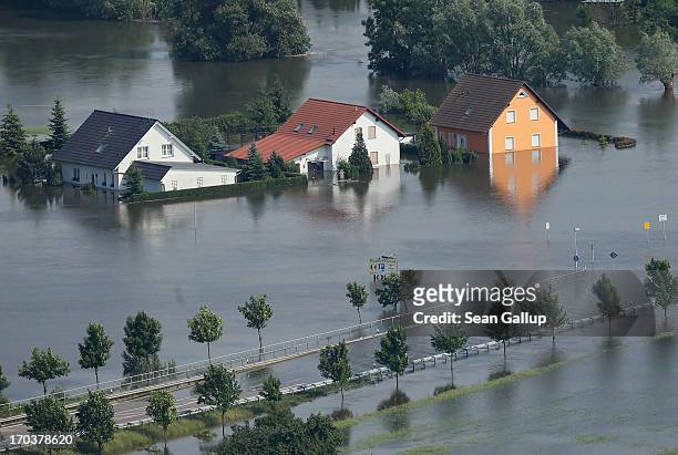 In this aerial view houses and a road stand partially submerged in floodwaters from the Elbe river on June 12, 2013 in Fischbeck, Germany. The...