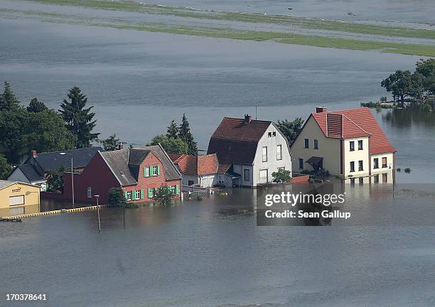 In this aerial view houses stand partially submerged in floodwaters from the Elbe river on June 12, 2013 in Fischbeck, Germany. The swollen Elbe is...