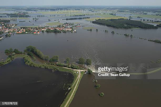 In this aerial view floodwater from the Elbe river flows across a burst dyke to flood land and villages on June 12, 2013 at Fischbeck, Germany. The...