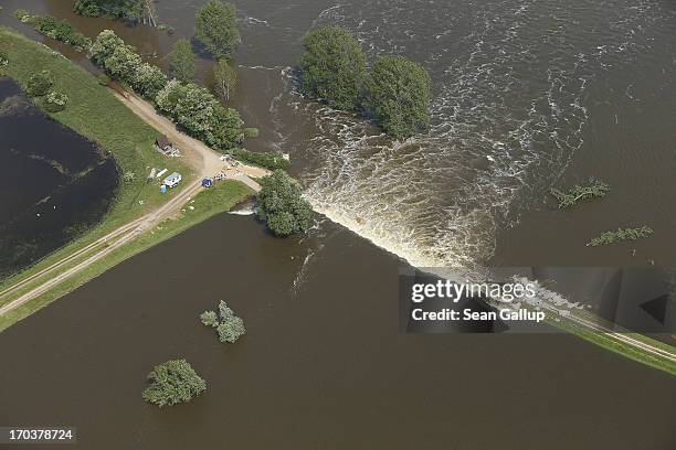 In this aerial view floodwater from the Elbe river flows across a burst dyke to flood land and villages on June 12, 2013 at Fischbeck, Germany. The...