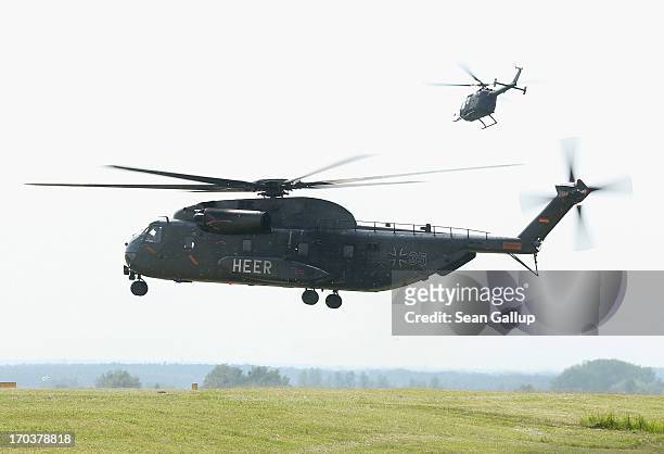 Two helicopters of the German Bundeswehr take off during emergency services for towns and villages hit by floods along the Elbe river on June 12,...
