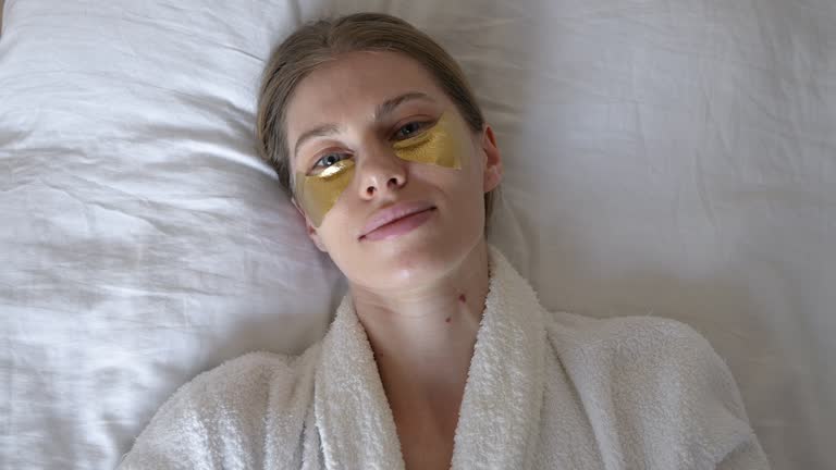 Resting Woman Robe A charming blonde woman in a white robe is resting at home with ...