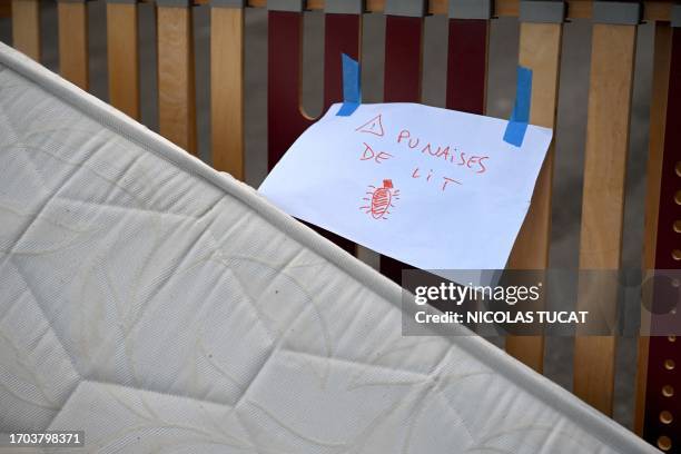 This photograph taken on October 3, 2023 shows a placard reading "Bed bugs" on a mattress abandoned on the pavement in a street in Marseille,...