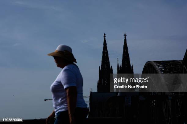A woman is seen on the other side of dom cathedral in cologne, Germany on Oct. 2. 2023 as warm weather bring unusually hot october temerature