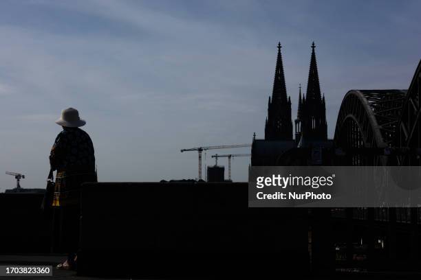 Woman is being seen on the other side of the Dom Cathedral in Cologne, Germany, on October 2 as the warm weather is bringing unusually high...