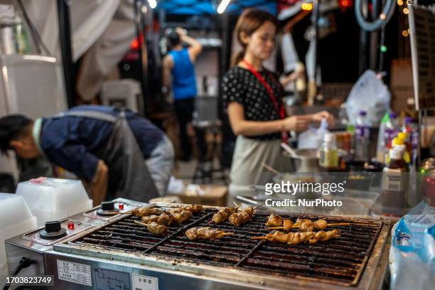 Vender cooking foods at a pop up night market in wan chai promenade on October 2, 2023 in Hong Kong, China. The Night Market in Wan Chai Promenade...