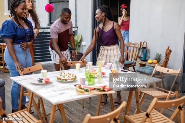 friends setting up for a relaxing party on the balcony - the party arrivals stock pictures, royalty-free photos & images
