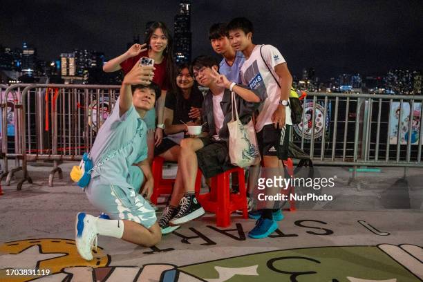 Group of people posing for a selfie at a pop up night market in wan chai promenade on October 2, 2023 in Hong Kong, China. The Night Market in Wan...