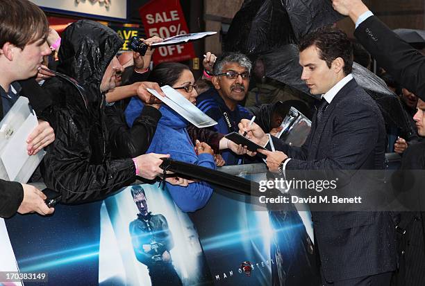 Actor Henry Cavill signs autographs for fans as he attends the UK Premiere of 'Man of Steel' at Odeon Leicester Square on June 12, 2013 in London,...