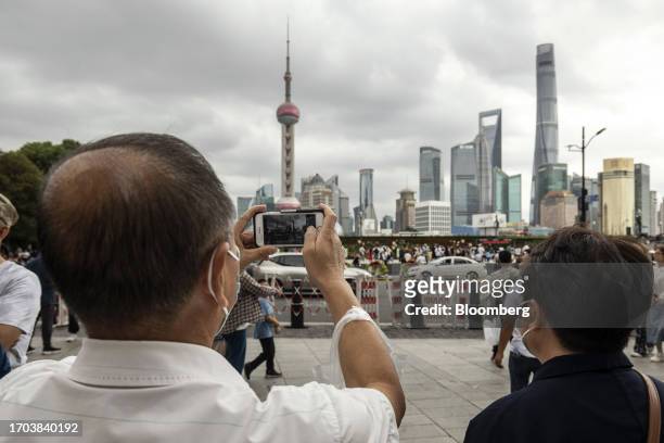 Pedestrians near the Bund in Shanghai, China, on Tuesday, Oct. 3, 2023. China's Golden Week got off to a promising start as tourist trips and revenue...