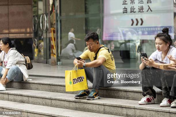 Pedestrians and shoppers rest on Nanjing Road shopping street in Shanghai, China, on Tuesday, Oct. 3, 2023. China's Golden Week got off to a...