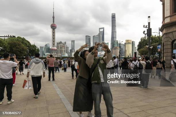 Pedestrians near the Bund in Shanghai, China, on Tuesday, Oct. 3, 2023. China's Golden Week got off to a promising start as tourist trips and revenue...