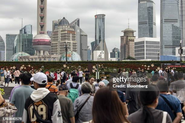Pedestrians along the Bund in Shanghai, China, on Tuesday, Oct. 3, 2023. China's Golden Week got off to a promising start as tourist trips and...