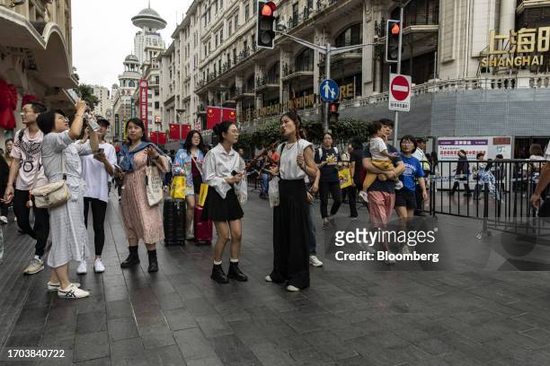 Pedestrians and shoppers on Nanjing Road shopping street in Shanghai, China, on Tuesday, Oct. 3, 2023. China's Golden Week got off to a promising...