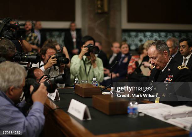 Army Gen. Keith Alexander, commander of the U.S. Cyber Command, director of the National Security Agency is surrounded by photographers after...