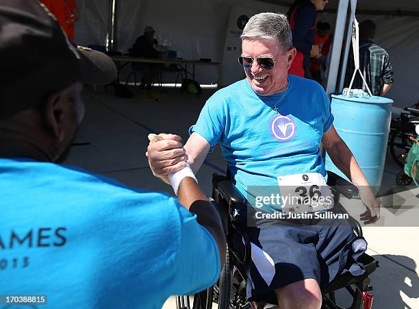 Disabled U.S. Navy veteran John Grimm shakes hands with disabled U.S. Army veteran Johnnie Alexander after lifting in the power lifting competition...