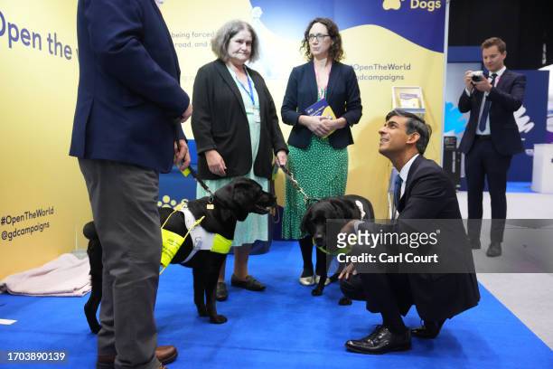 British Prime Minister Rishi Sunak greets guide dogs as he tours the Exhibitor's Hall on Day 3 of the Conservative Party Conference on October 3,...