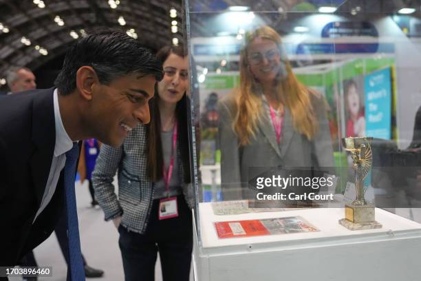 British Prime Minister Rishi Sunak looks at an exhibit as he tours the Exhibitor's Hall on Day 3 of the Conservative Party Conference on October 3,...