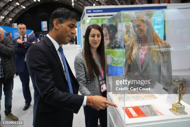 British Prime Minister Rishi Sunak looks at an exhibit as he tours the Exhibitor's Hall on Day 3 of the Conservative Party Conference on October 3,...