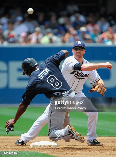 Logan Forsythe of the San Diego Padres throws over Justin Upton of the Atlanta Braves as he turns a double play during the third inning of a baseball...