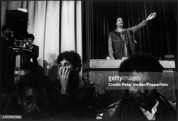 Standing on a podium behind security guards, Muammar Gaddafi , leader of the State of Libya, addresses an indoor rally in Tripoli, Libya on 15th...