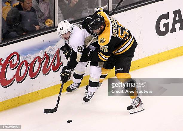 Sidney Crosby of the Pittsburgh Penguins handles the puck against Johnny Boychuk of the Boston Bruins in Game Four of the Eastern Conference Final...