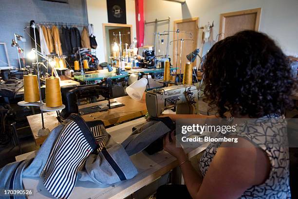 An employee sews a pair of denim jeans at Detroit Denim, in Detroit, Michigan, U.S., on Wednesday, June 12, 2013. The Commerce Department is...