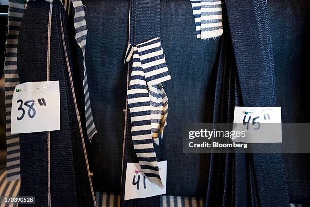 Variety of different sized denim jeans sit unfinished on a rack at Detroit Denim, in Detroit, Michigan, U.S., on Wednesday, June 12, 2013. The...